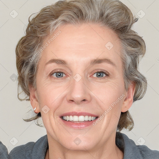 Joyful white adult female with medium  brown hair and blue eyes