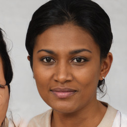 Joyful black young-adult female with medium  brown hair and brown eyes