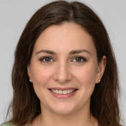 Joyful white young-adult female with long  brown hair and green eyes