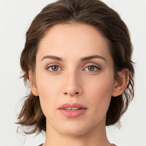 Joyful white young-adult female with medium  brown hair and green eyes