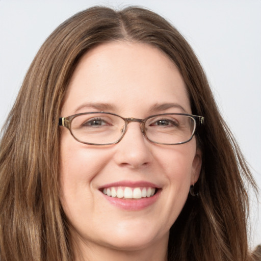 Joyful white adult female with long  brown hair and blue eyes