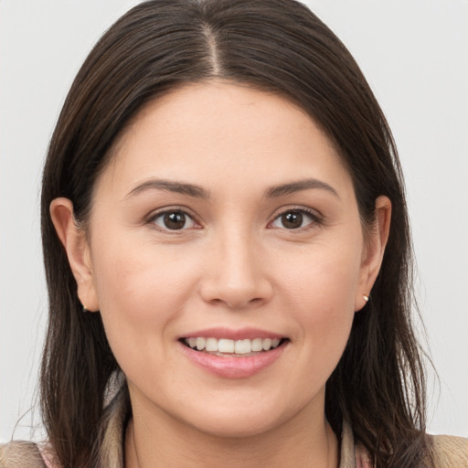 Joyful white young-adult female with long  brown hair and brown eyes