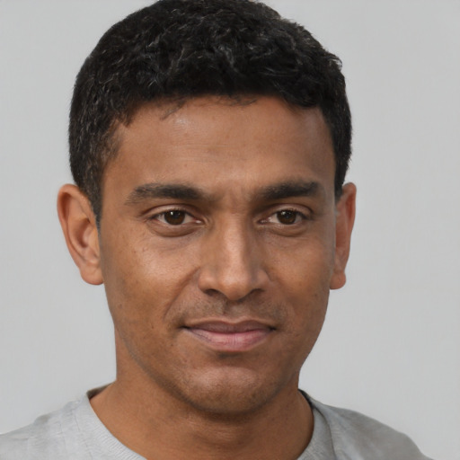 Joyful latino young-adult male with short  brown hair and brown eyes