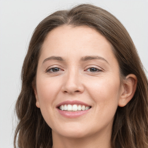 Joyful white young-adult female with long  brown hair and grey eyes