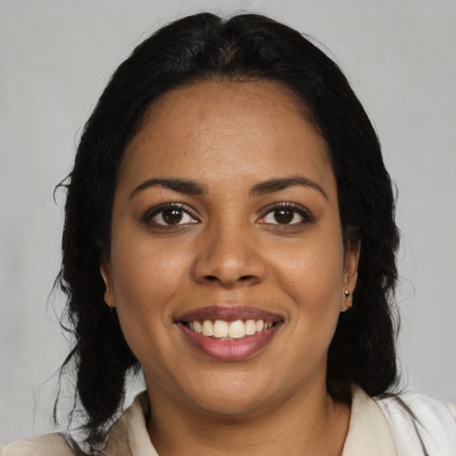 Joyful black young-adult female with long  black hair and brown eyes