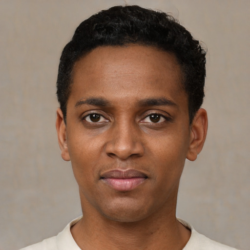 Joyful black young-adult male with short  black hair and brown eyes