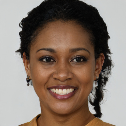 Joyful black young-adult female with short  black hair and brown eyes
