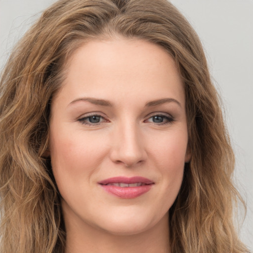 Joyful white young-adult female with long  brown hair and green eyes