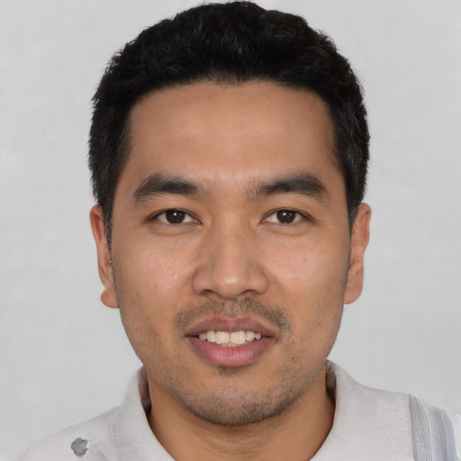 Joyful asian young-adult male with short  black hair and brown eyes