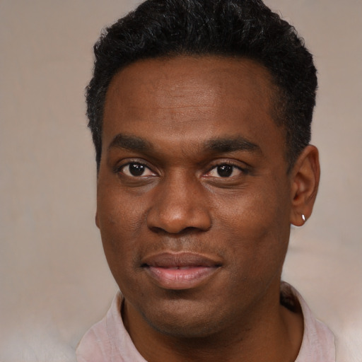 Joyful black young-adult male with short  black hair and brown eyes
