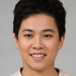 Joyful asian young-adult male with short  brown hair and brown eyes