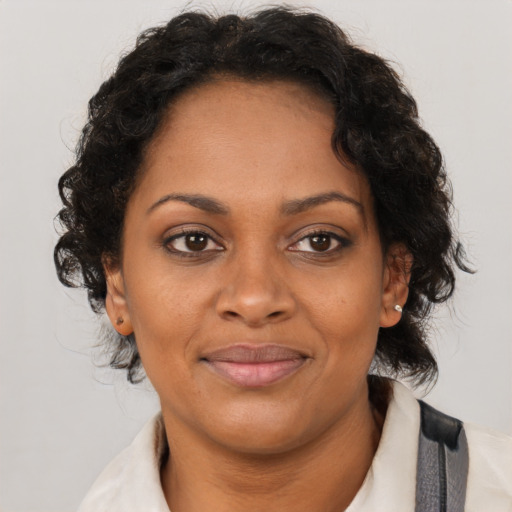 Joyful black adult female with medium  brown hair and brown eyes