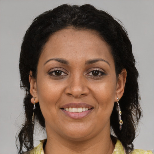 Joyful latino adult female with medium  brown hair and brown eyes