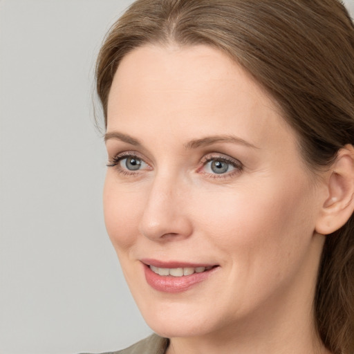 Joyful white young-adult female with long  brown hair and grey eyes