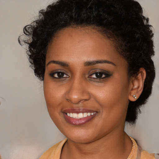 Joyful black young-adult female with medium  brown hair and brown eyes