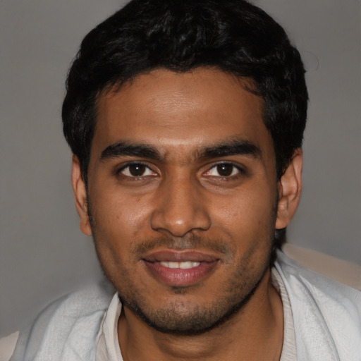 Joyful black young-adult male with short  black hair and brown eyes