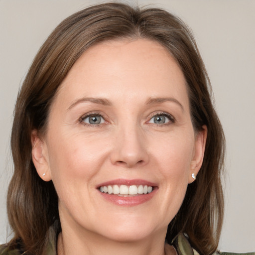 Joyful white adult female with medium  brown hair and grey eyes