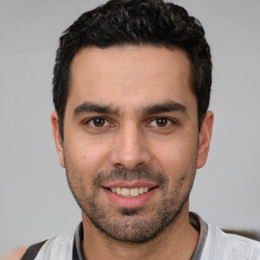 Joyful white young-adult male with short  black hair and brown eyes