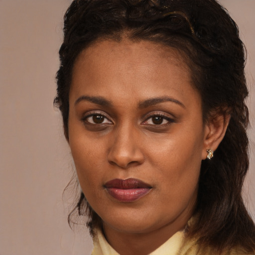 Joyful black young-adult female with long  brown hair and brown eyes