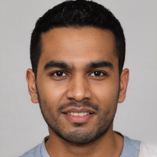 Joyful latino young-adult male with short  black hair and brown eyes