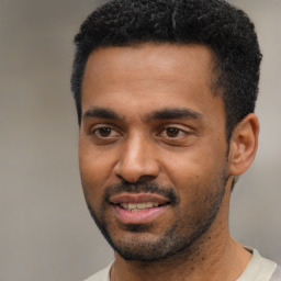 Joyful black young-adult male with short  black hair and brown eyes