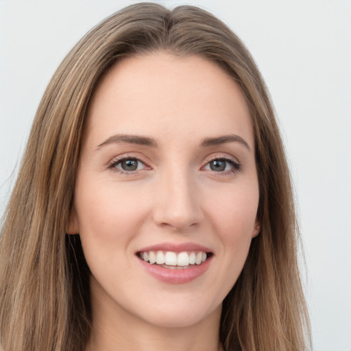 Joyful white young-adult female with long  brown hair and green eyes