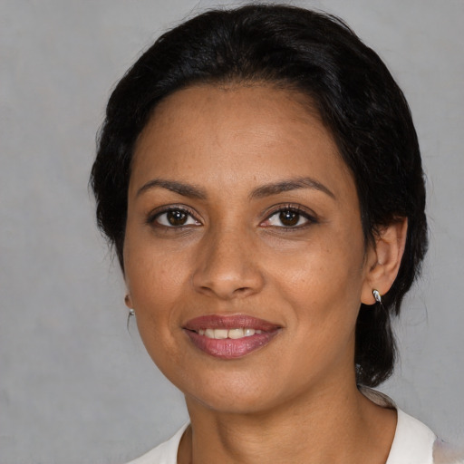 Joyful latino adult female with medium  black hair and brown eyes
