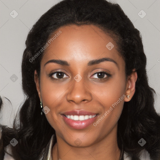 Joyful black young-adult female with long  black hair and brown eyes