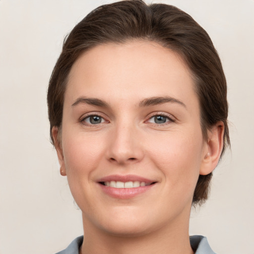 Joyful white young-adult female with medium  brown hair and grey eyes