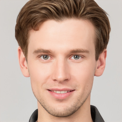 Joyful white young-adult male with short  brown hair and grey eyes