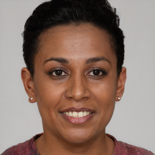 Joyful black young-adult female with short  brown hair and brown eyes
