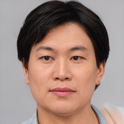Joyful asian adult male with short  brown hair and brown eyes