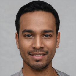 Joyful latino young-adult male with short  black hair and brown eyes