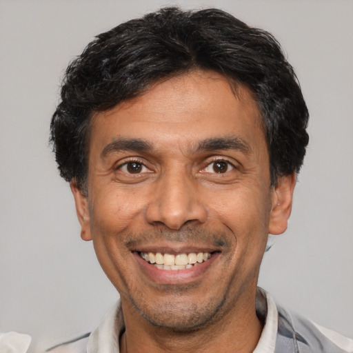 Joyful white adult male with short  black hair and brown eyes