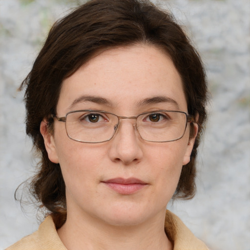 Joyful white adult female with medium  brown hair and green eyes