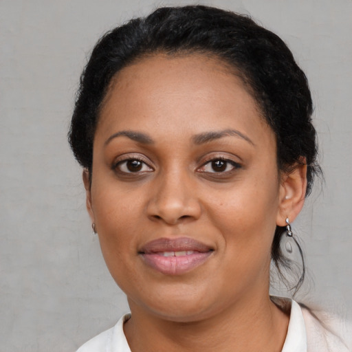 Joyful black young-adult female with short  black hair and brown eyes