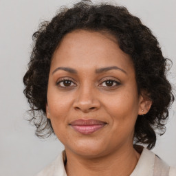 Joyful black adult female with medium  brown hair and brown eyes