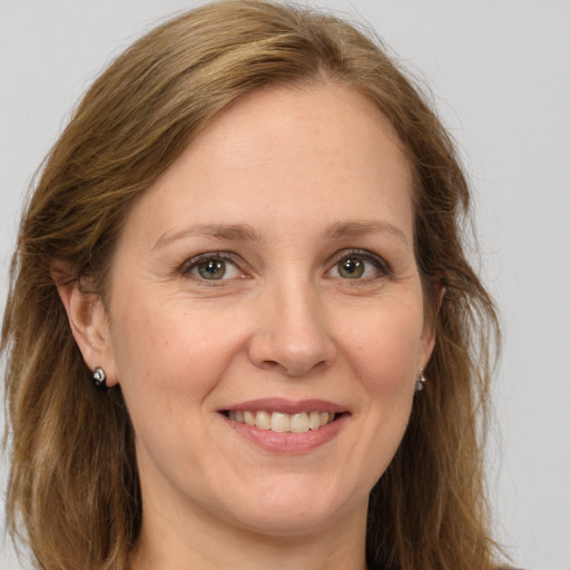 Joyful white adult female with long  brown hair and green eyes