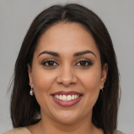 Joyful latino young-adult female with medium  brown hair and brown eyes