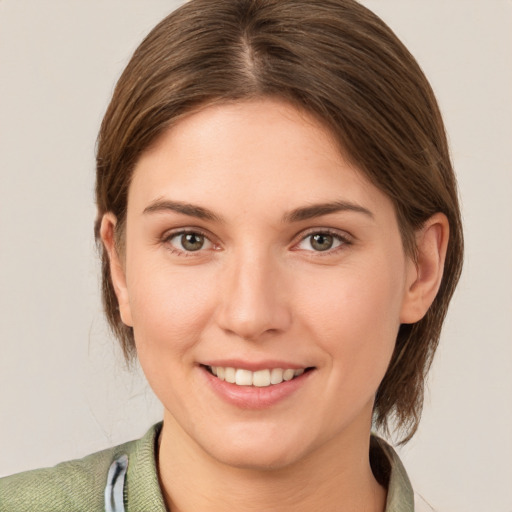 Joyful white young-adult female with medium  brown hair and grey eyes