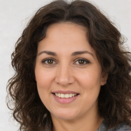 Joyful white adult female with long  brown hair and brown eyes