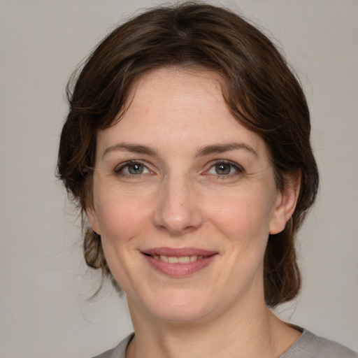 Joyful white adult female with medium  brown hair and grey eyes