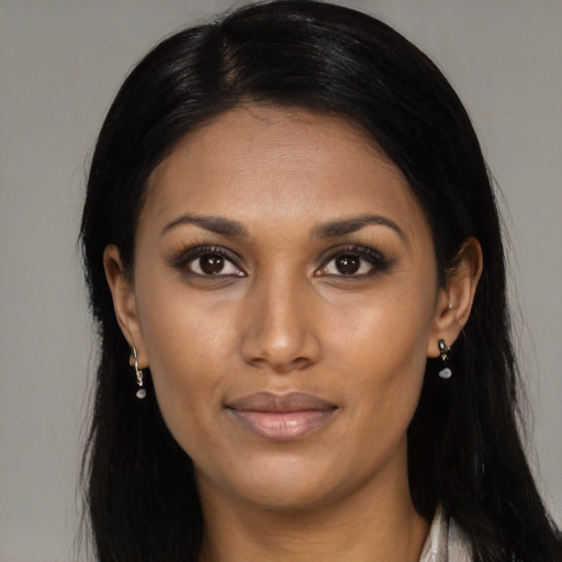 Joyful black young-adult female with long  black hair and brown eyes