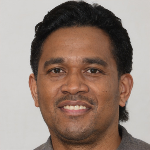 Joyful latino adult male with short  black hair and brown eyes