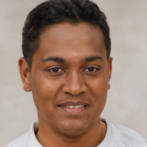 Joyful black young-adult male with short  brown hair and brown eyes