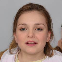 Joyful white child female with medium  brown hair and blue eyes