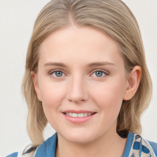 Joyful white young-adult female with medium  brown hair and blue eyes