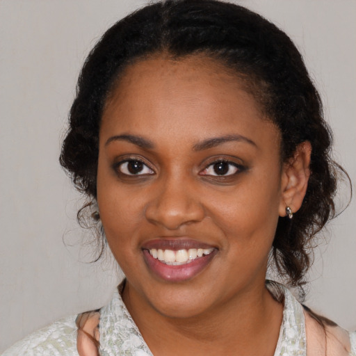 Joyful black young-adult female with medium  black hair and brown eyes