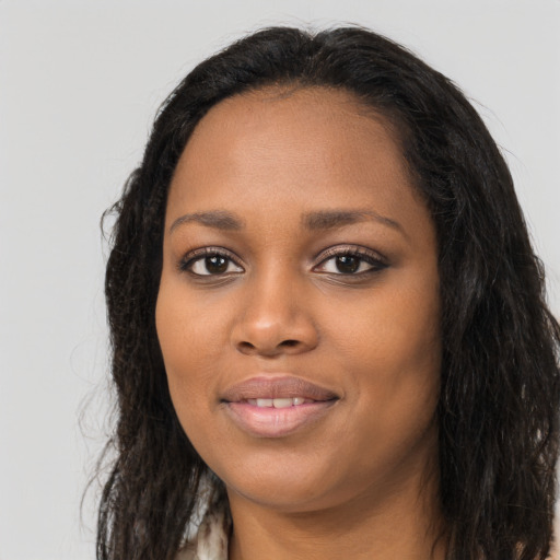 Joyful black young-adult female with long  black hair and brown eyes
