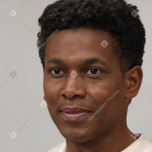 Joyful black young-adult male with short  black hair and brown eyes